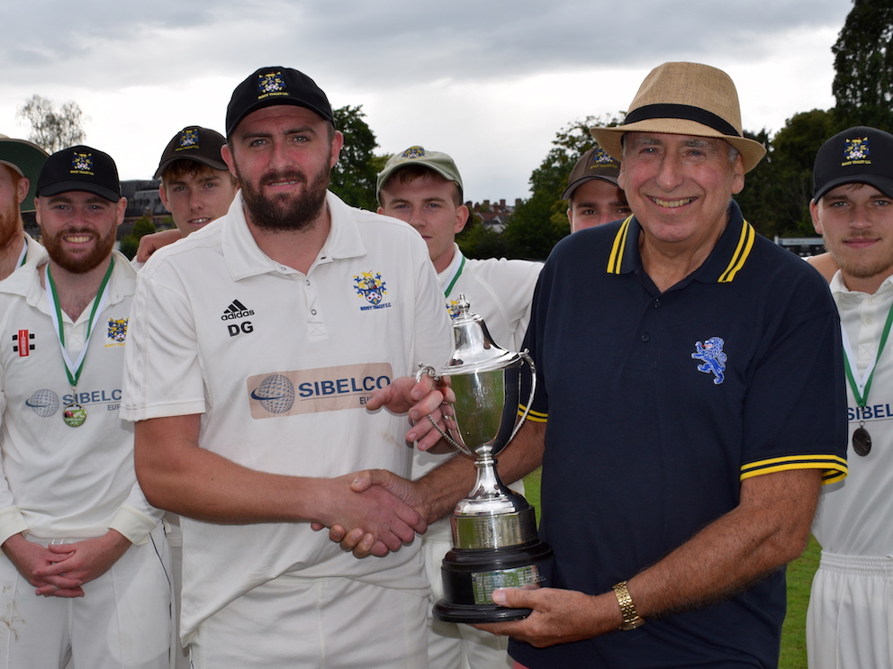 Bovey Tracey 2nd XI captain Dan Green collects the Aaron Printers Cup from Michael Hunt on behalf of the sponsor
